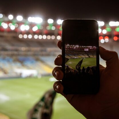 martphone photographing football game on the stadium